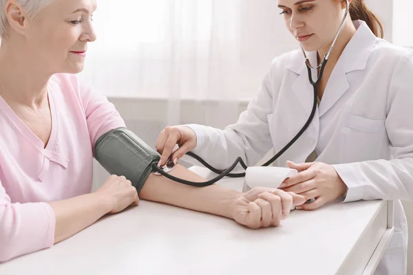Arzt misst arteriellen Blutdruck bei älteren Patienten — Stockfoto