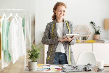 Moda tasarımcısı tablete yeni taslak koleksiyonu çiziyor