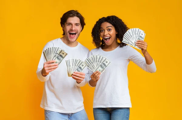 Feliz pareja sosteniendo mucho dinero en efectivo en las manos, regocijando el éxito — Foto de Stock