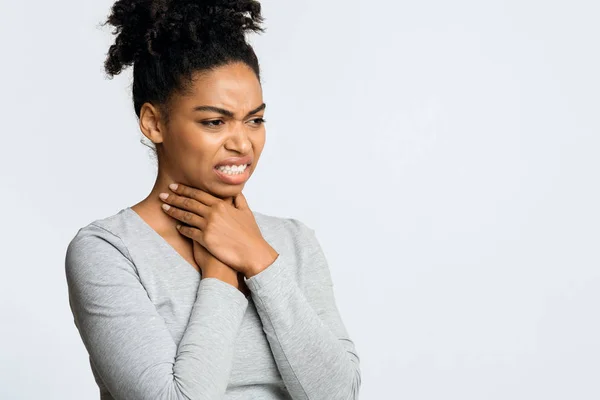 Afro chica que sufre de dolor de garganta, tocándose el cuello —  Fotos de Stock