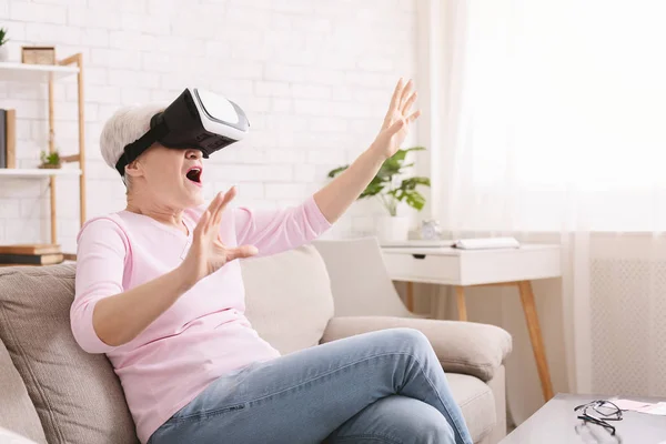 Señora mayor sorprendida disfrutando de la realidad virtual en los auriculares VR — Foto de Stock
