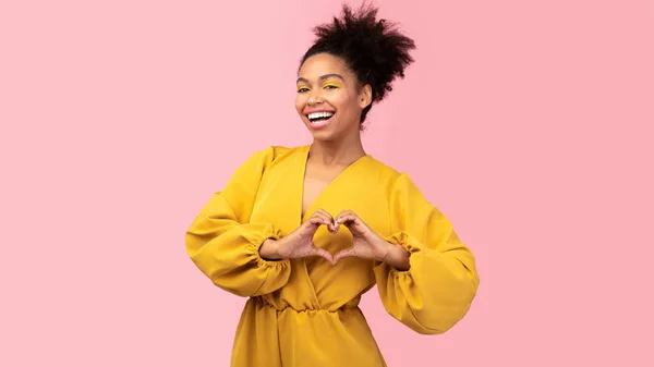 Gülümseyen Afrikalı Amerikalı kız kalp hareketi gösteriyor. — Stok fotoğraf
