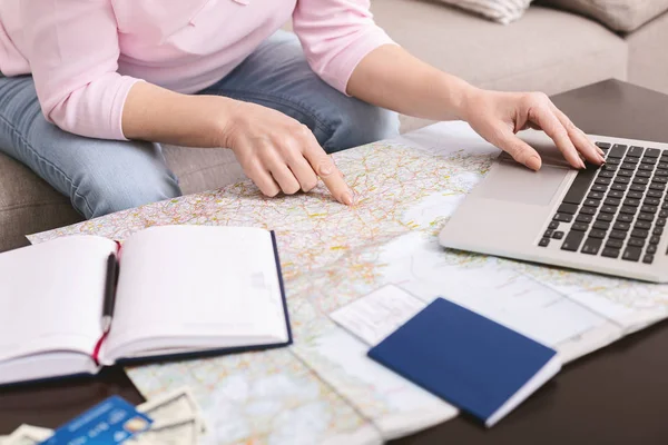 Senior woman choosing trip on map, booking hotel on laptop — 스톡 사진