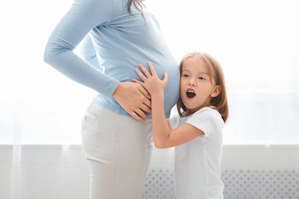 Enfant préscolaire émotionnel écoutant maman enceinte ventre — Photo