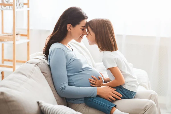 Jovem mulher grávida de ligação com sua filhinha — Fotografia de Stock