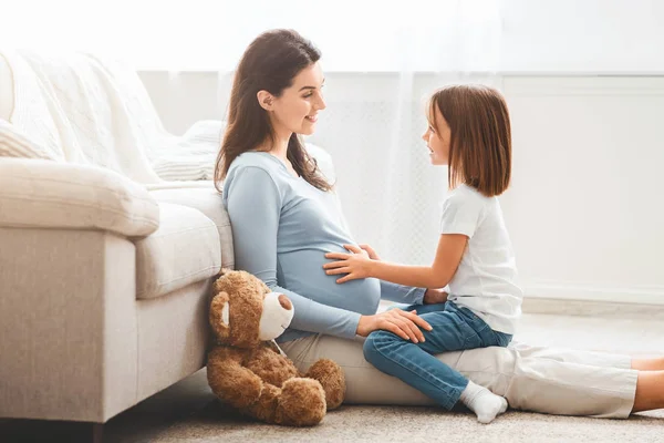 Peaceful picture of expecting young mother and daughter playing together — Stock Photo, Image
