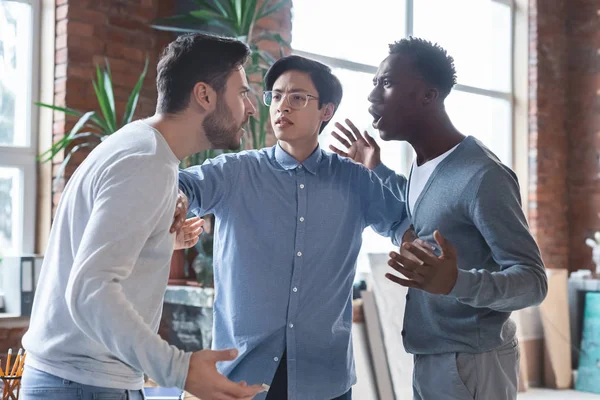 Young angry coworkers having quarrel at office — Stock Photo, Image