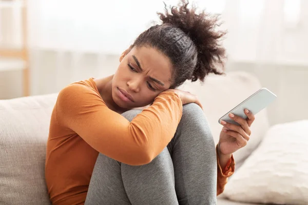 Gadis Unhappy Millennial Memegang Telepon Duduk Pada Sofa Di Rumah — Stok Foto
