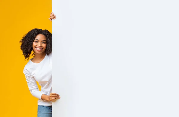 Fröhliche Afro-Frau mit großer weißer Werbetafel mit freiem Platz — Stockfoto