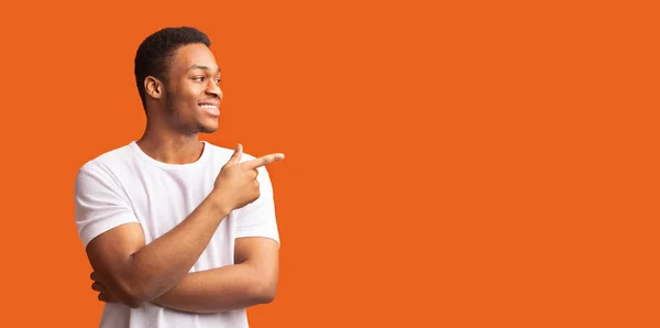 Joven hombre negro apuntando al espacio de copia con el pulgar hacia arriba — Foto de Stock