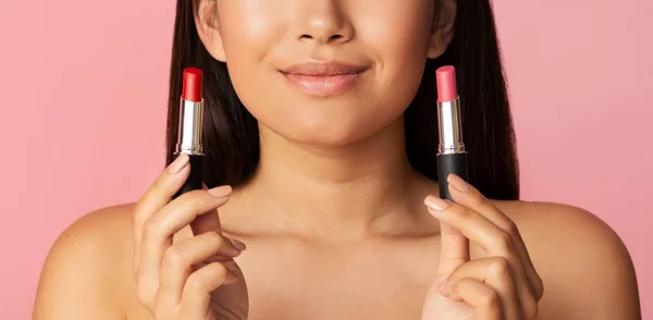 Le flicka med två läppstift, välj mellan rött och rosa — Stockfoto