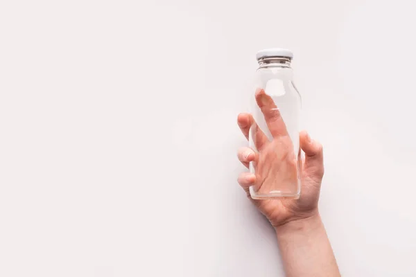 Prázdné skleněná láhev v ženské ruce na bílém pozadí — Stock fotografie