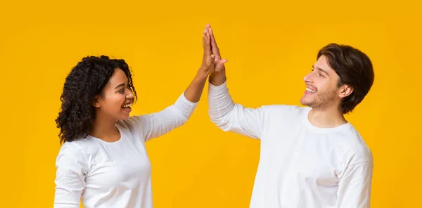 Positivo interracial pareja aplaudiendo manos, dando chocar los cinco a la otra — Foto de Stock