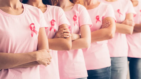 Senhoras irreconhecíveis na consciência do câncer camisetas posando sobre fundo branco — Fotografia de Stock