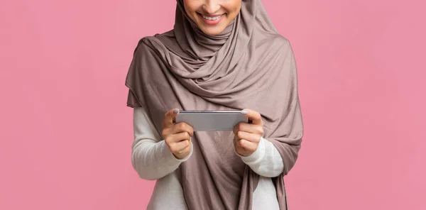 Smartphone dalam orientasi horisontal di tangan wanita tak dikenal dalam hijab — Stok Foto