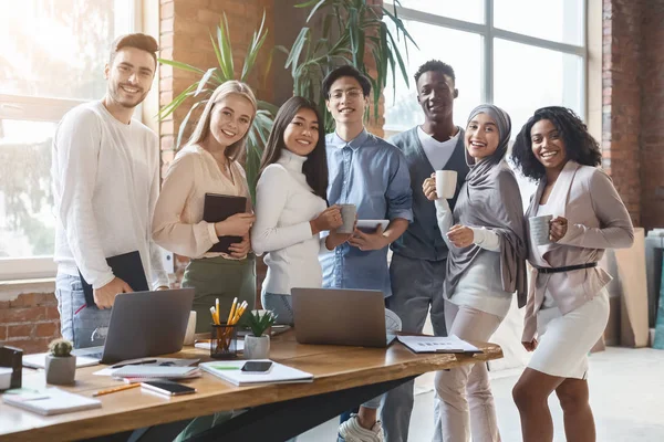 Happy young business team poseren in functie tijdens de werkdag — Stockfoto