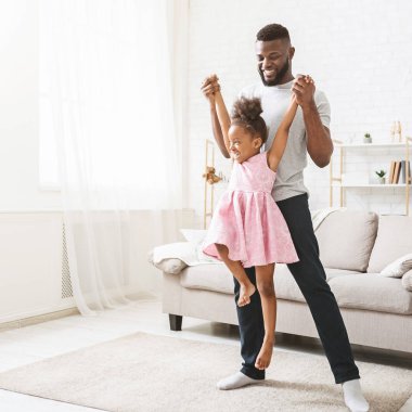 Güzel elbiseli neşeli afro kız babasıyla oynuyor.