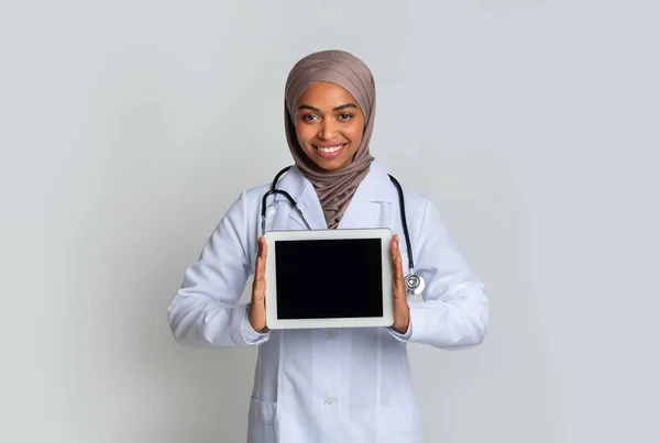 Digitales Tablet mit schwarzem Bildschirm in den Händen schwarzer muslimischer Ärztin im Hijab — Stockfoto