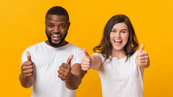 Túl boldog multiracionális pár mutatja hüvelykujját fel a kamera, ajánló hűvös ajánlatot — Stock Fotó