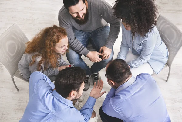 Diversos jóvenes sentados en círculo discutiendo el plan de trabajo, vista superior — Foto de Stock