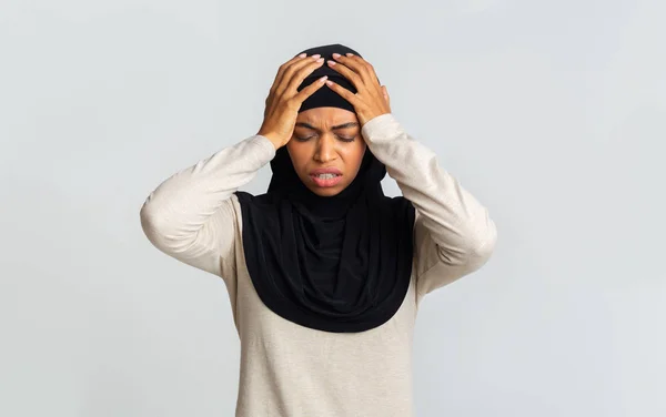 Doente senhora muçulmano preto em lenço de cabeça tocando sua cabeça com as mãos — Fotografia de Stock