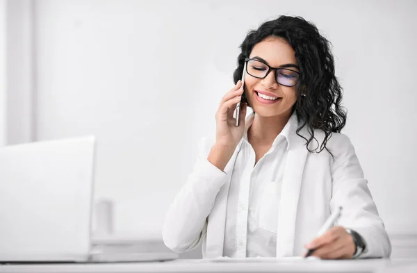 Latynoska bizneswoman rozmawia przez telefon i pisze — Zdjęcie stockowe