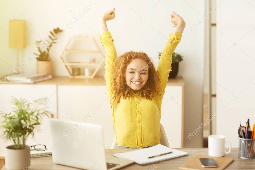 Happy businesswoman sitting at her workplace in office