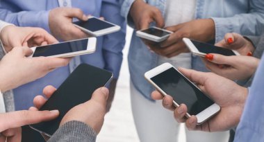 Çevrede akıllı telefonları olan çeşitli insanların yakın çekimi.