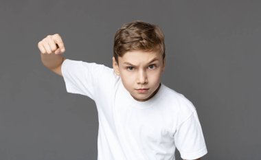 Furious teenager punching fist with anger at camera