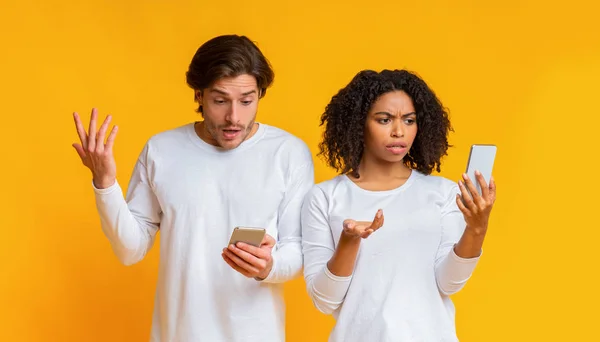 Teleurgesteld interraciale paar met smartphones problemen met wifi-verbinding — Stockfoto