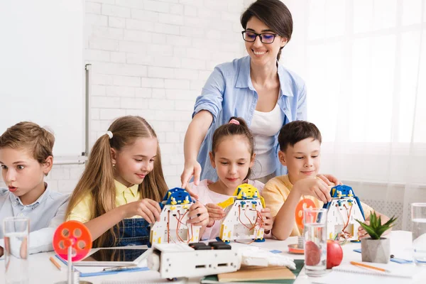 Pupils constructing modern robots with teachers help — Stock Photo, Image