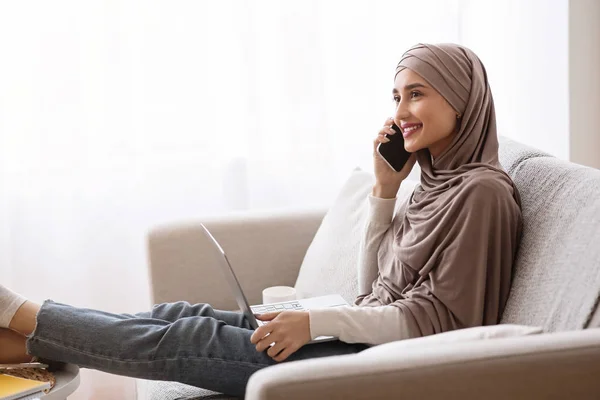 Smiling Muslim Girl In Hijab Having Phone Conversation And using Laptop — Stok Foto