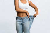 Mladá černošky žena na sobě příliš velké džíny