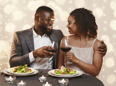 Young black couple having festive dinner at restaurant