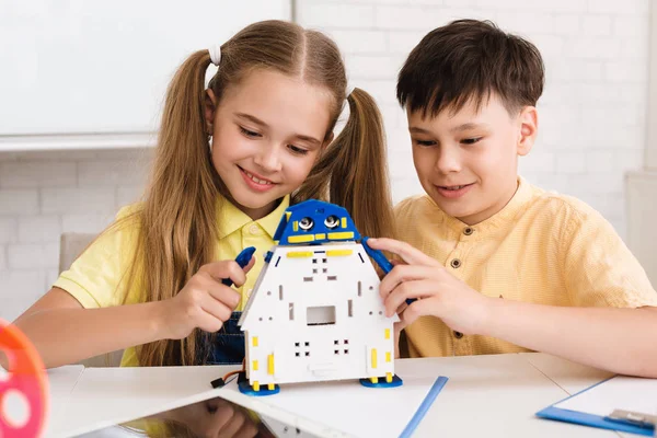 Escuela de niño y niña creando robot moderno en la clase de tallo — Foto de Stock