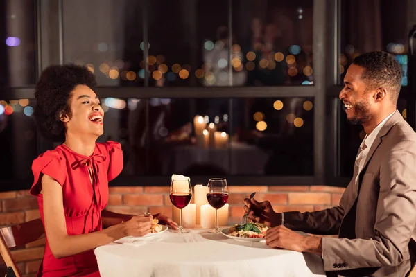 Paar plaudert und lacht beim Abendessen in schickem Restaurant — Stockfoto