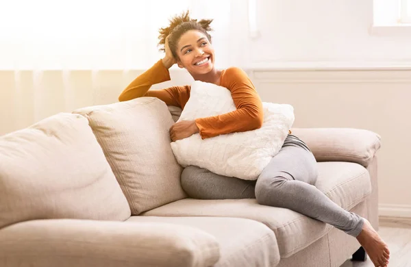 Allegro nero ragazza seduta su divano relax a casa — Foto Stock