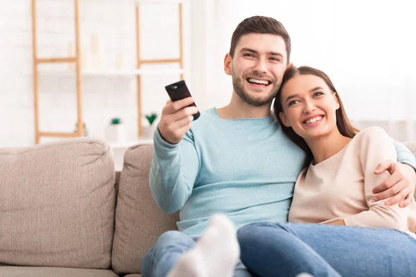 Casal assistindo TV relaxante sentado no sofá em casa — Fotografia de Stock