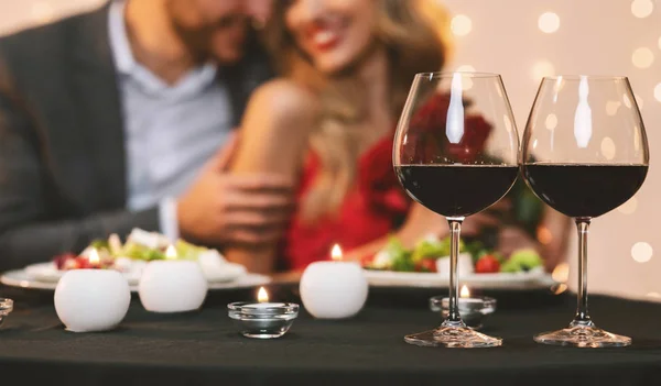 Casal desfrutando de jantar romântico no restaurante, foco seletivo em copos de vinho — Fotografia de Stock