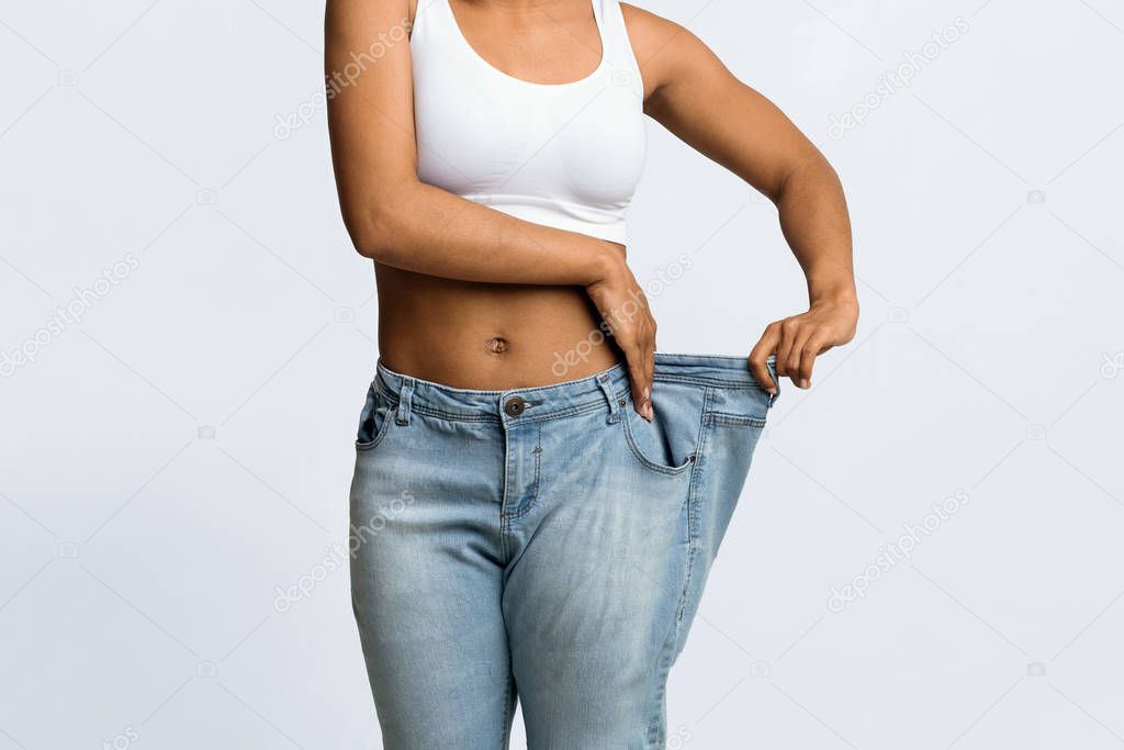 Young black woman wearing too large jeans