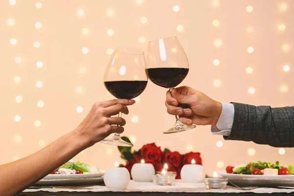 Romantyczna para brzęczących kieliszków z czerwonym winem na randkę w restauracji — Zdjęcie stockowe