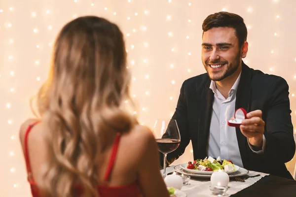 Homem pedindo namorada para se casar com ele no jantar romântico no restaurante — Fotografia de Stock