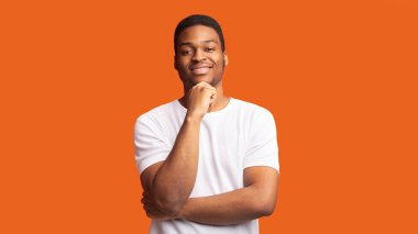 Turuncu arka planda dalgın afro adam portresi