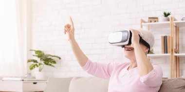 Neşeli yaşlı bayan modern teknolojinin tadını çıkarıyor.