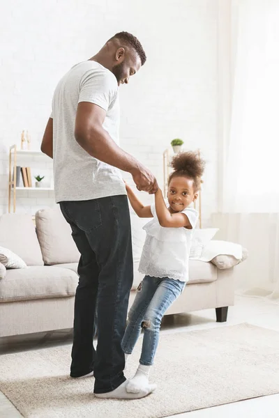 Jovem pai africano e pequena filha se divertindo em casa — Fotografia de Stock