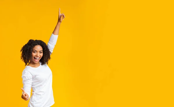 Vreugdevol Afrikaans Amerikaans meisje dansen, handen omhoog en kijken naar de camera — Stockfoto