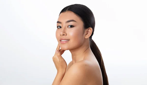 Belleza asiática. Retrato de una hermosa chica tocando su suave piel — Foto de Stock