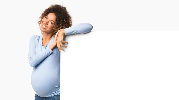 Super offre. Happy afro femme enceinte près affiche vierge — Photo