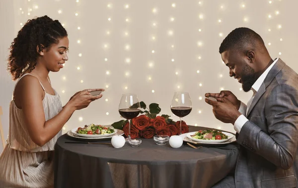 Μαύρο ζευγάρι λήψη φωτογραφιών του γεύματος στο εστιατόριο — Φωτογραφία Αρχείου