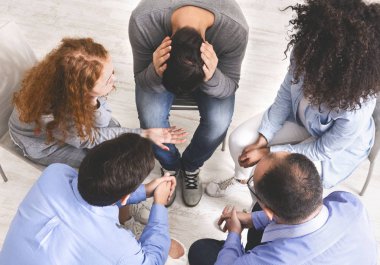 Sorunlarını güven çemberinde tartışan bir grup insan.